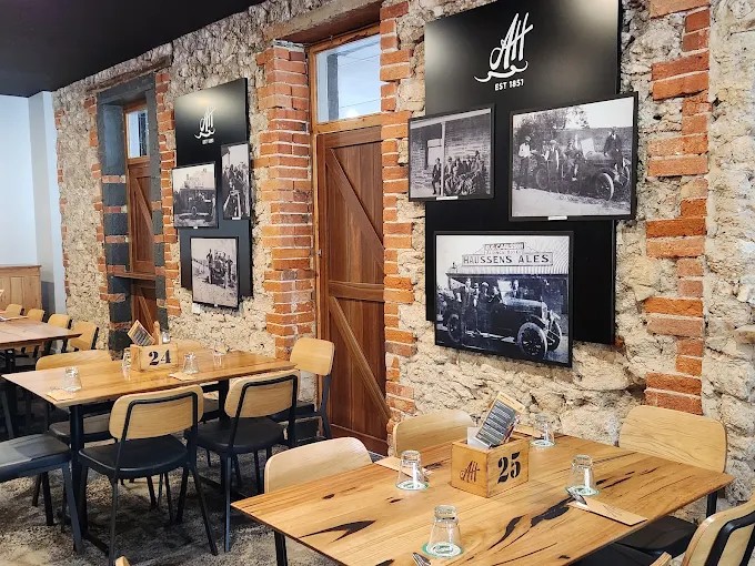 Bistro tables beside the original stone and brick walls with historic photos