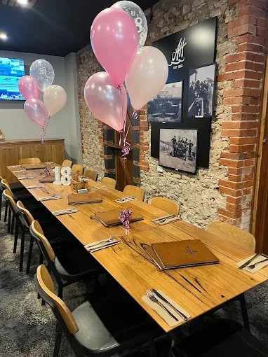 A long function table set for an 18th birthday with pink balloons